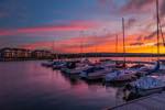 image of the harbour and the sunset toward Blue Mountain with light glowing off the shipyards development by the water.