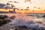 a splash of the water in the foreground with sunset and collingwood's terminals building in the background