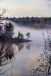 mist rolling around an island in twelve mile bay of the Muskoka Region Ontario